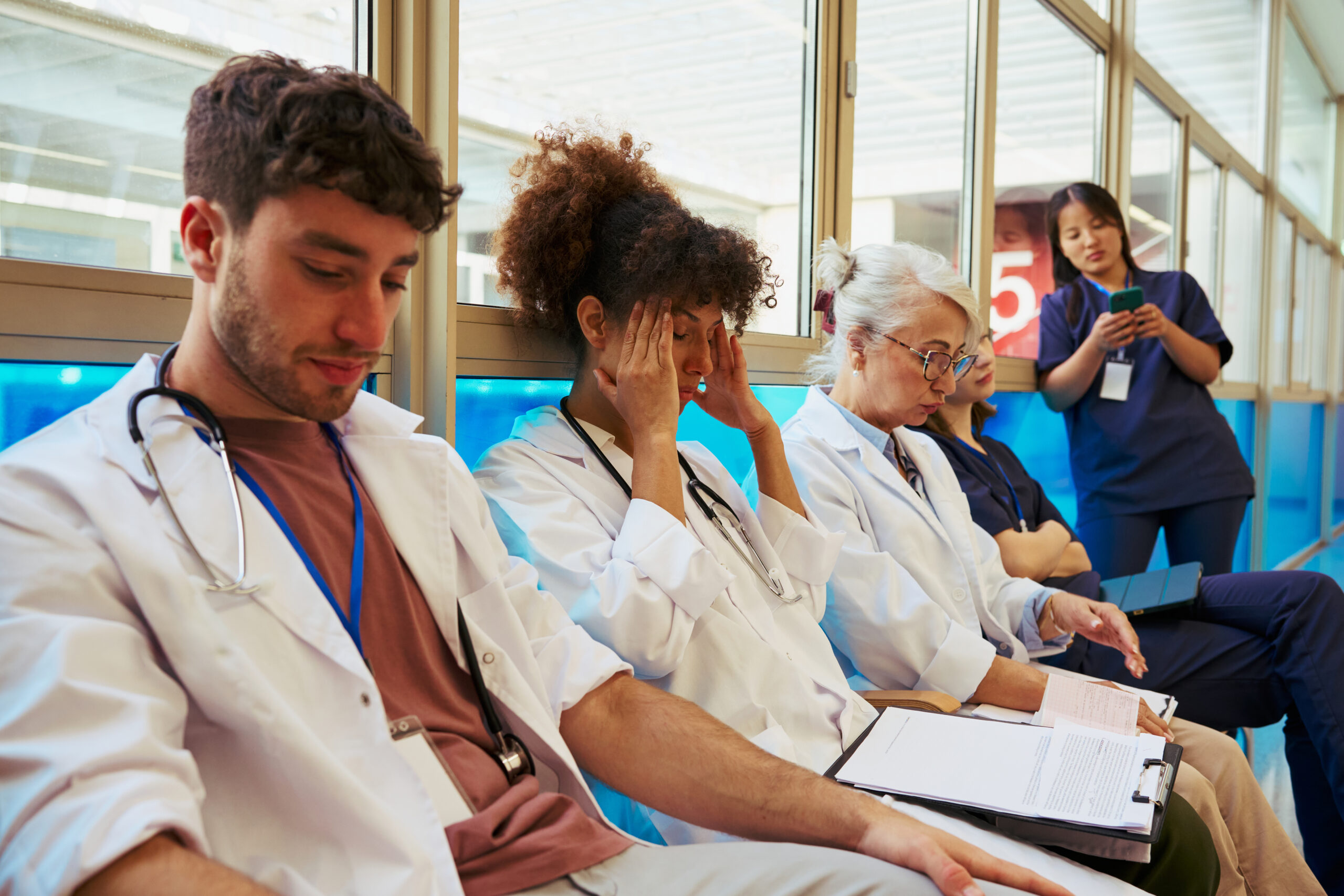tired-doctors-and-nurses-sitting-in-hospital-corri-2026-01-09-10-54-37-utc