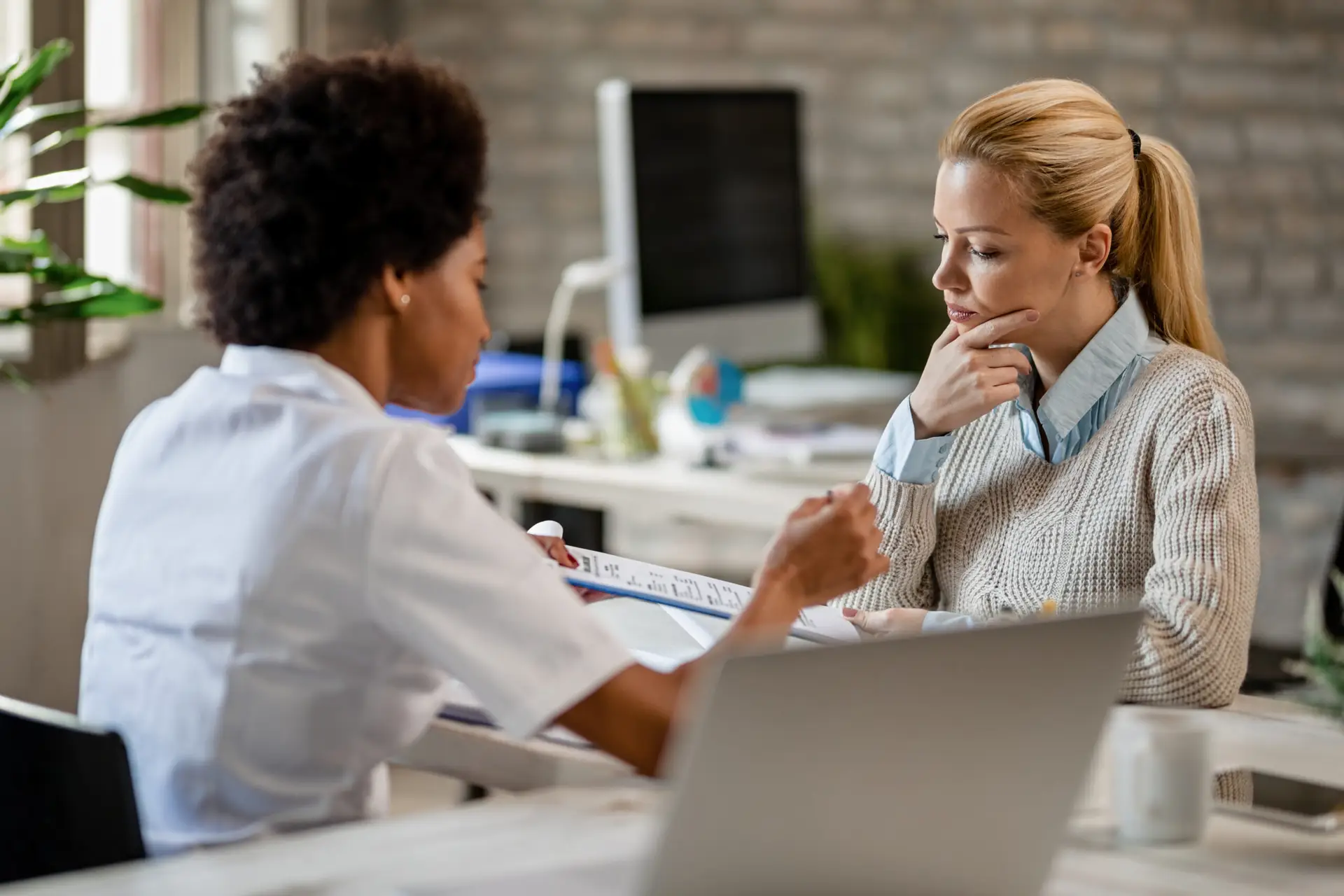 pensive-woman-and-her-doctor-analyzing-medical-rep-2026-03-17-07-06-23-utc